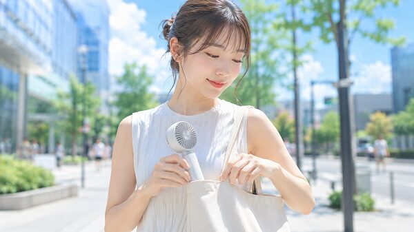 バッグからハンディファンを取り出して使うイメージ